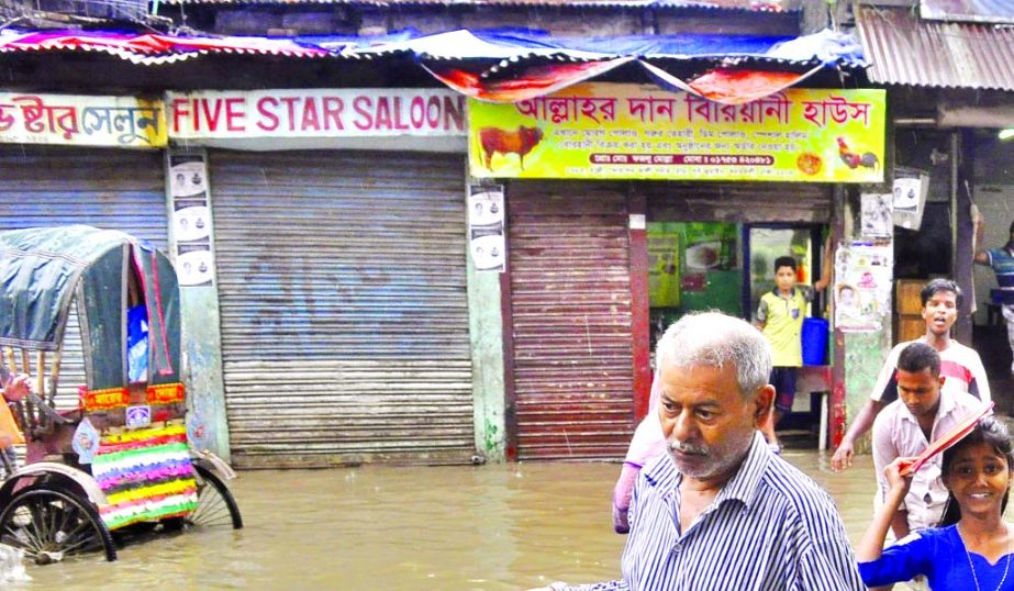 Students and locals wading through rain water as these are stagnant at DND area for several days. This photo was taken from Shyampur Kadamtali area on Monday.