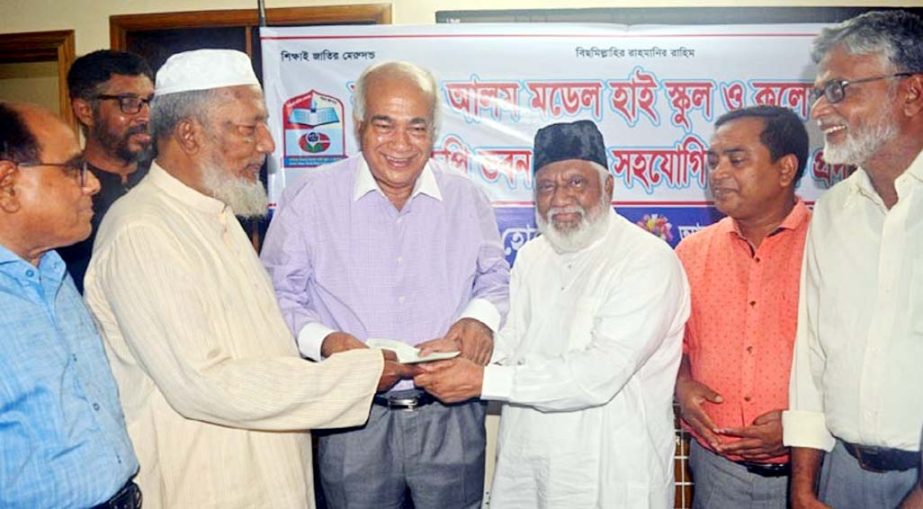 Chairman of PHP family Industrialist Sufi Mohammed Mizanur Rahman handing over a cheque to Housing and Public Works Minister Engineer Mosharraf Hossain for construction of a building for Bodiul Alam School and College in Mirsharai on Sunday.