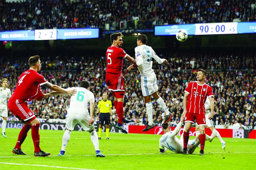Bayern's Mats Hummels (center left) and Real Madrid's Raphael Varane go for a header during the Champions League semifinal second leg soccer match between Real Madrid and FC Bayern Munich at the Santiago Bernabeu stadium in Madrid, Spain on Tuesday.