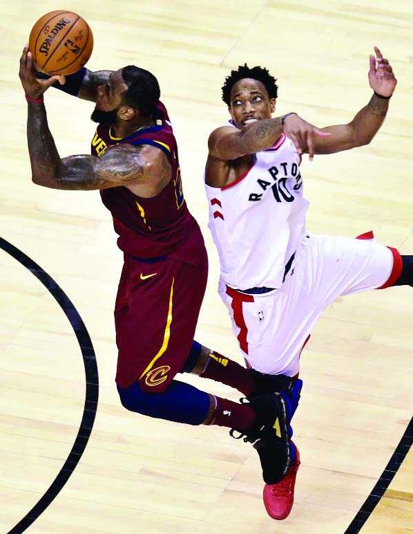 Cleveland Cavaliers forward LeBron James (23) shoots after the shot clock had expired, as Toronto Raptors guard DeMar DeRozan (10) defends during overtime in Game 1 of an NBA basketball playoffs Eastern Conference semifinal in Toronto on Tuesday.