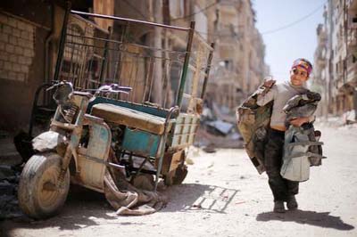 A boy walks along a damaged street at the city of Douma in Damascus, Syria