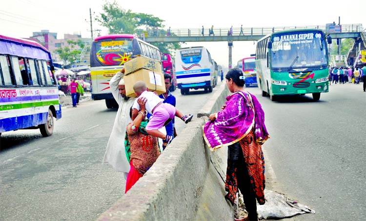 Pedestrians crossing the road divider taking big risk of life. This is a busy road on Dhaka-Chittagong highway at eastern city gate in which hundreds of vehicles ply by an hour every day. These people are careless of the risk although fatal accidents take