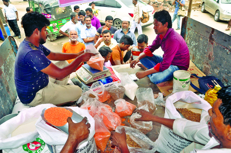 People rush at TCB's goods-laden truck at different city areas to buy essentials at fixed price ahead of Ramzan. This photo was taken on Monday.