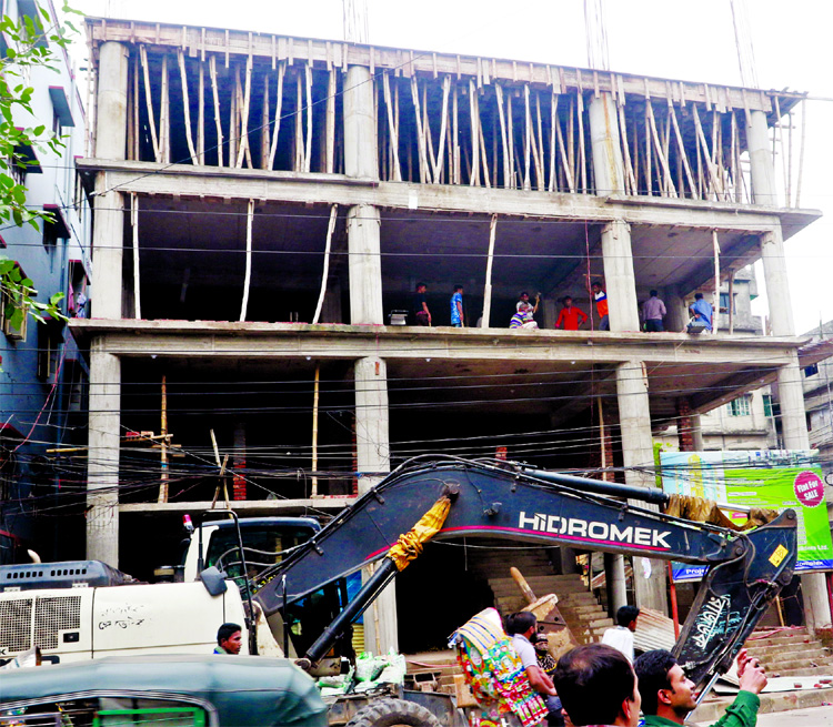 RAJUK authorities dismantling a portion of the unauthorised building at Shahid Faruk Road in city's Jatrabari area on Monday.