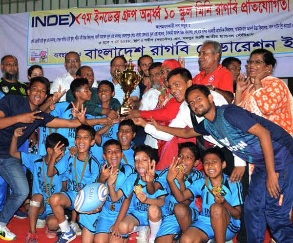 Members of Ali Ahmed School and College Rugby team, who became champion in Index Under 10 mimi Rugby competition pose for photo with trophy at the Shaheed (Captain) M Mansur Ali National Handball Stadium on Monday.