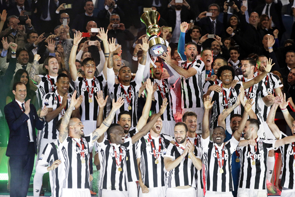 Juventus player celebrate with the trophy after beating AC Milan 4-0 in the Italian Cup final soccer match, at the Rome Olympic stadium on Wednesday.
