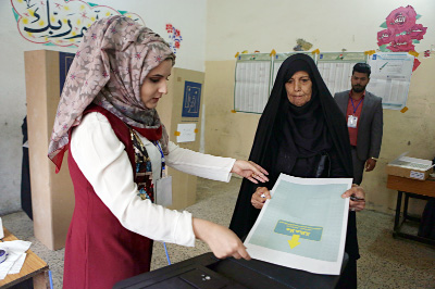 An Iraqi woman casts her vote in the country's parliamentary elections in Baghdad, Iraq on Saturday