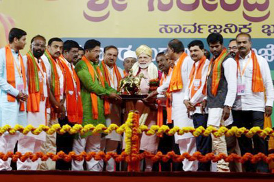 India's Prime Minister Narendra Modi receives a memento as he attends an election campaign rally ahead of the Karnataka state assembly elections in Bengaluru, India.