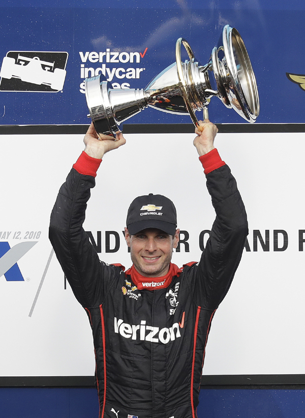 Will Power of Australia holds the trophy after winning the IndyCar Grand Prix auto race at Indianapolis Motor Speedway in Indianapolis on Saturday.