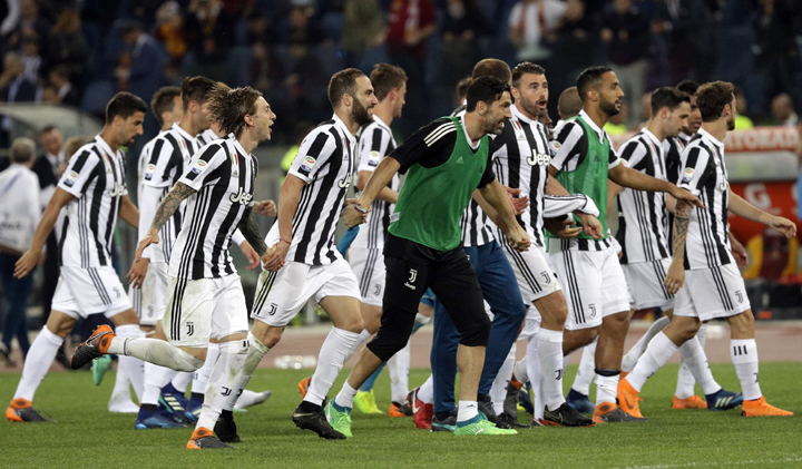 Juventus players celebrate at the end of the Serie A soccer match between Roma and Juventus, at the Rome Olympic stadium on Sunday. The match ended in a scoreless draw and Juventus won record-extending seventh straight Serie A title.