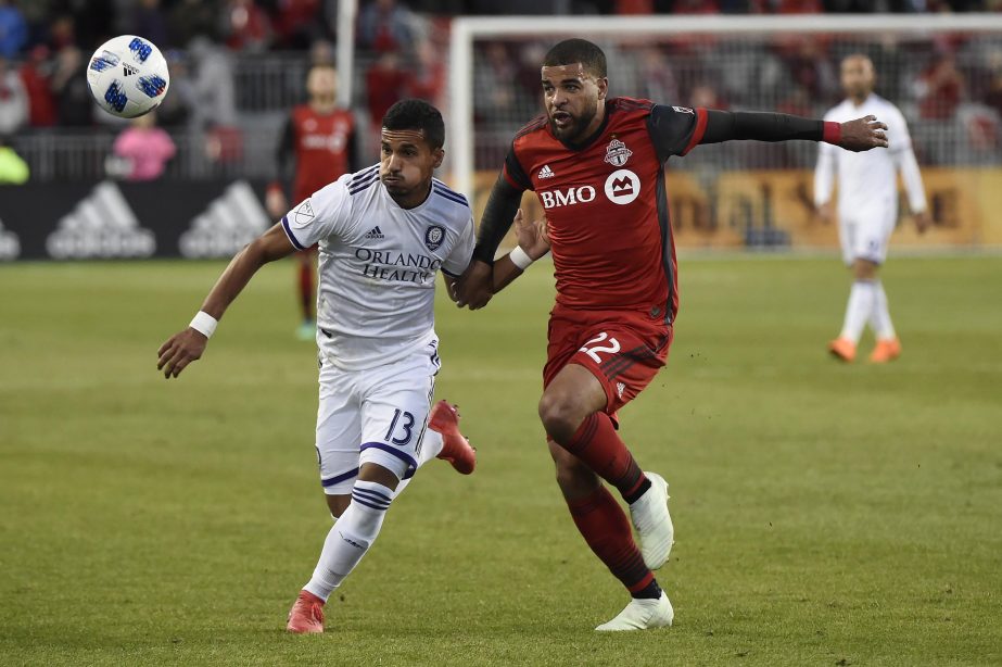 Toronto FC forward Jordan Hamilton (22) and Orlando City defender Mohamed El-Munir (13) chase the bouncing ball during the first half of an MLS soccer match in Toronto on Friday.