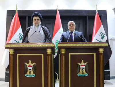 Iraqi Shi'ite cleric Moqtada al-Sadr (L) speaks during a news conference with Iraqi Prime Minister Haider al-Abadi in Baghdad, Iraq on Sunday.