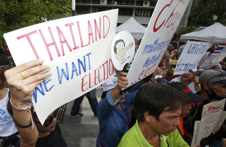 Pro-democracy demonstrators holding posters in Bangkok.