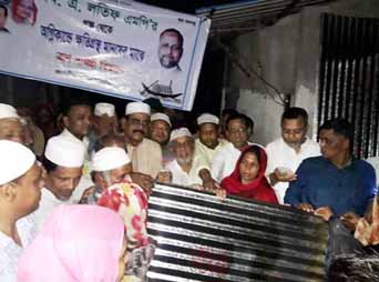 MA Latif MP distributing relief goods among the fire-affected people in Chattogram city yesterday.