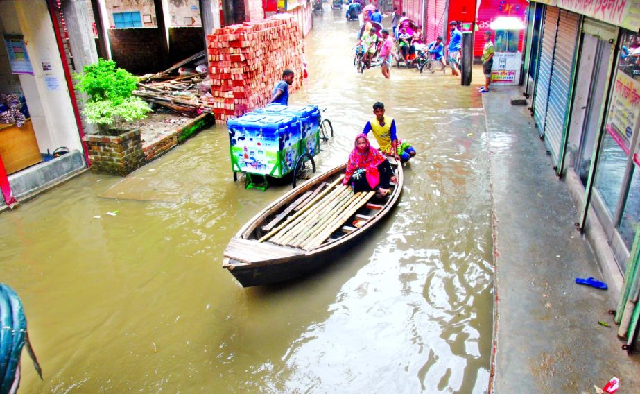 The main thoroughfare at Ragerbagh area went under knee deep water as rain waters are stagnant for a few days. Locals using boat side by side with-rickshaw, van to help pass the pedestrians as transport during this monsoon.