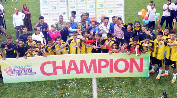 Members of Saif Sporting Youth team, the champions of the Saif Power Battery 5th BKSP Cup Under-18 Football Tournament with the guests and officials of BKSP pose for a photo session at the BKSP Ground in Savar on Tuesday.