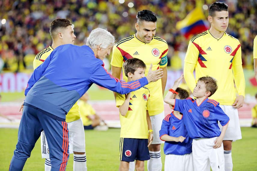 Colombia's national soccer team coach Jose Pekerman greets a boy next to James Rodriguez (right) and Radamel Falco Garcia, second from right, prior to an exhibition match at the Nemesio Camacho stadium in Bogota, Colombia on Friday. Colombia will warm up