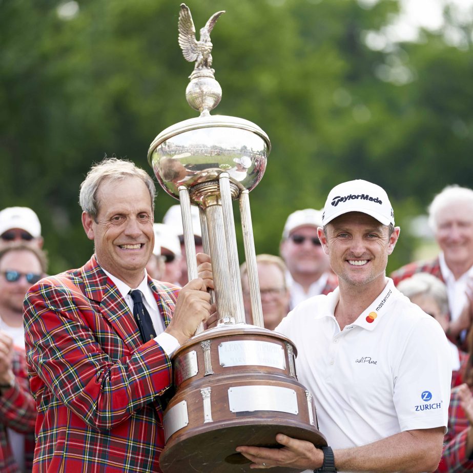 Justin Rose, of England (right) receives the trophy from Colonial Country Club President Rob Doby (left) after winning the Fort Worth Invitational golf tournament at Colonial Country Club in Fort Worth, Texas on Sunday.