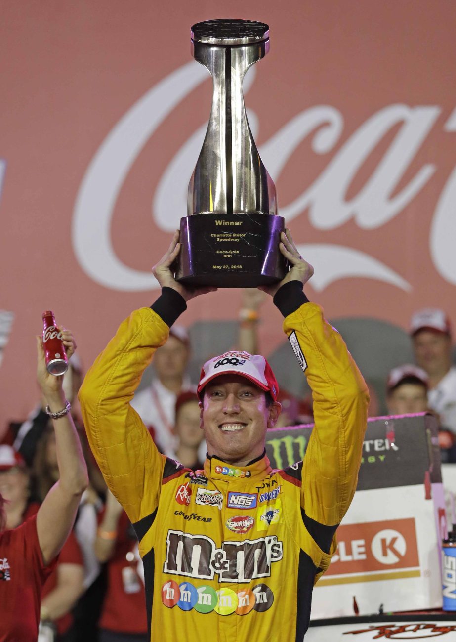Kyle Busch raises the trophy in Victory Lane after winning the NASCAR Cup Series auto race at Charlotte Motor Speedway in Charlotte, N.C., Sunday.