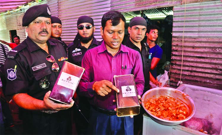 Members of RAB-1 mobile court led by a magistrate showing seized packets of colour, that are being mixed with Iftar items, while inspecting Khushbu Restaurant at Gulshan. They also sealed-off a unit of the restaurant and fined Taka four lakh on Monday.