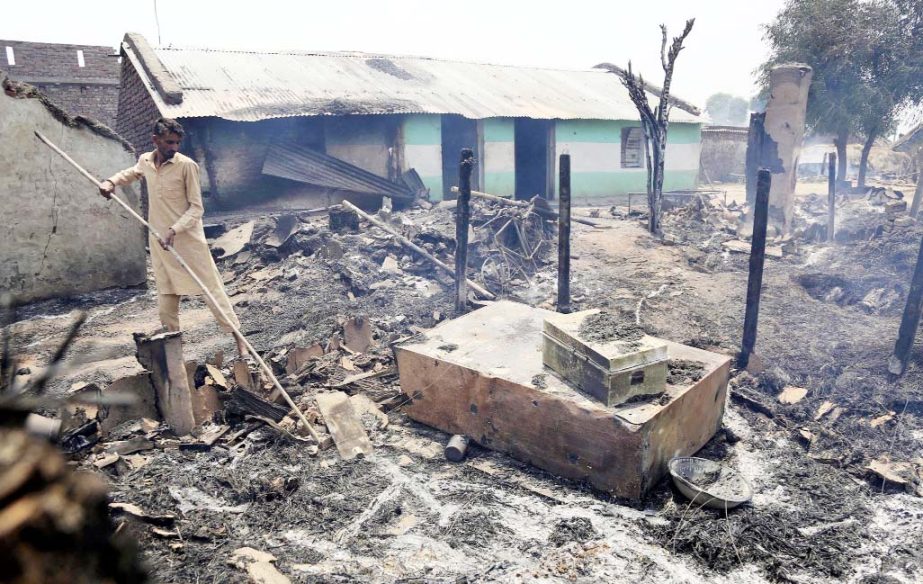 An Indian man inspects the damage after his home was gutted by firing allegedly from the Pakistan side of the border