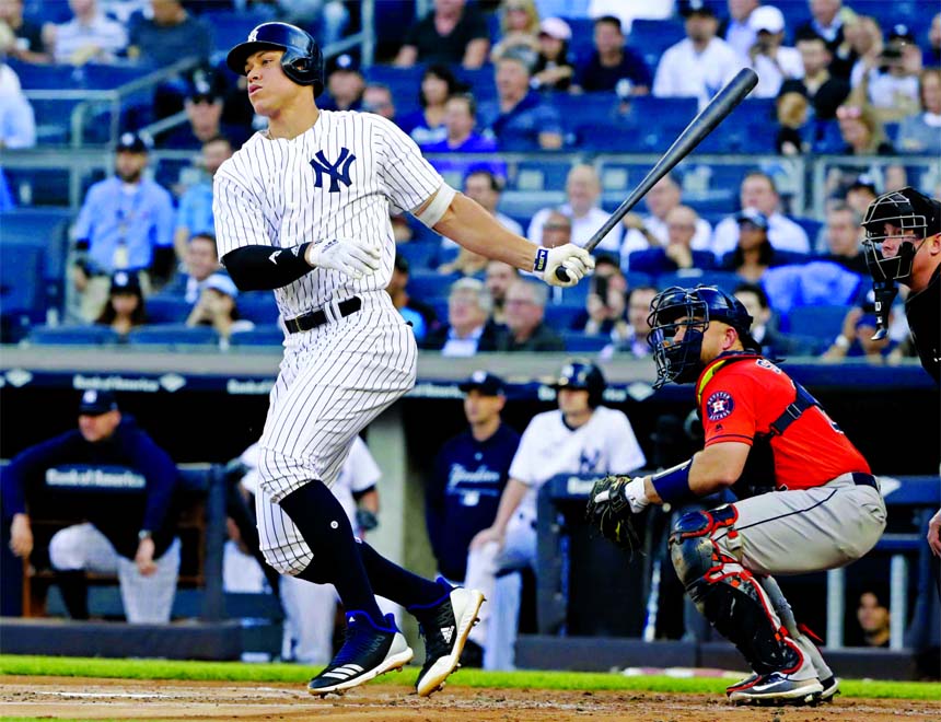 New York Yankees' Aaron Judge follows through on a single during the first inning as Houston Astros catcher Max Stassi (right) watches during a baseball game in New York on Wednesday .