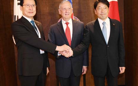 South Koreas Defence Minister Song Young-moo, Japan's Defence Minister Itsunori Onodera and US Secretary of Defence James Mattis shake hands in Singapore.