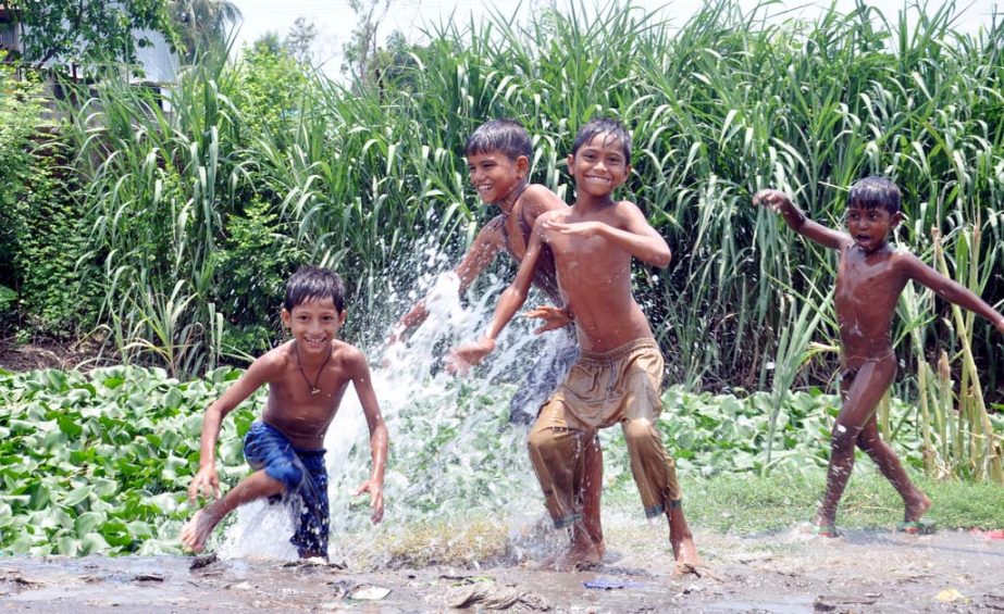 Children are relaxing by taking bath as a pipe of a WASA line has been broken at Sagorik Stadium area on Sunday.