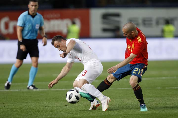 Switzerland's Xherdan Shaqiri (left) fights for the ball against Spain's Silva during the friendly soccer match between Spain and Switzerland at the Ceramica stadium in Villarreal, Spain on Sunday.