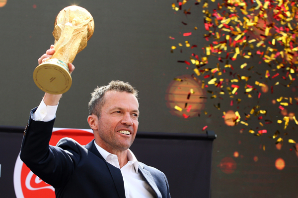 Former German soccer star Lothar Matthaus holds up the trophy during a ceremony to welcome the FIFA World Cup trophy at Manezh Square in Moscow, Russia on Sunday.