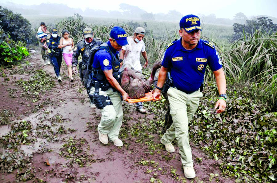 Police officers carry a man injured by the eruption of Guatemala's Fuego volcano.