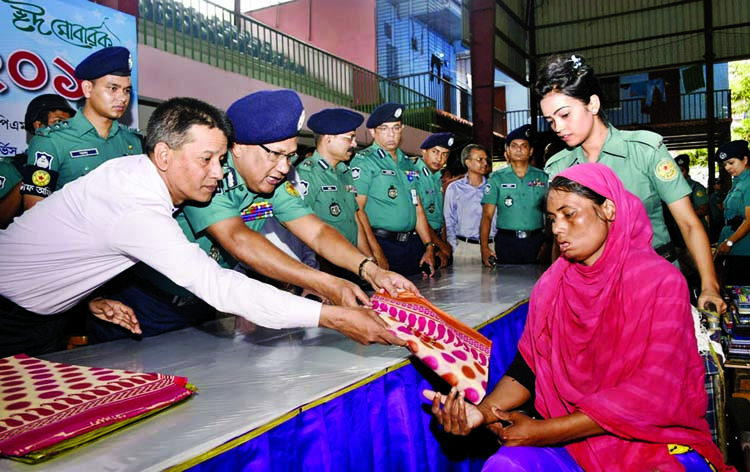 DMP Commissioner Asaduzzaman Mia distributing Eid clothes among destitute at Bangladesh Handball Federation Stadium in the city on Tuesday on the occasion of holy Eid-ul-Fitr.