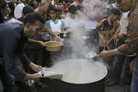 Distributes free porridge during the holy fasting month of Ramzan in Gaza City.