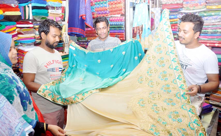 Shopkeepers at CDA Market showing new collections of sharees to buyers as Eid shopping getting momentum in the Port City. This nap was taken yesterday.