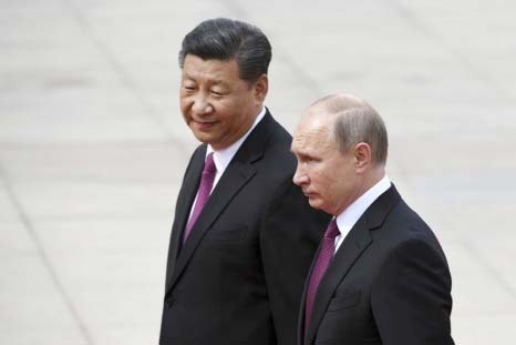 President Vladimir Putin, (right), reviews a military honor guard with Chinese President Xi Jinping during a welcoming ceremony outside the Great Hall of the People in Beijing on Friday.