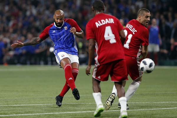 France's Thierry Henry (left) shots the ball past Aldair of Brazil (center) and Nisa Saveljic of Serbia (right) during a charity soccer match between members of the 1998 World Cup winning French team and a team of international veteran players who were a