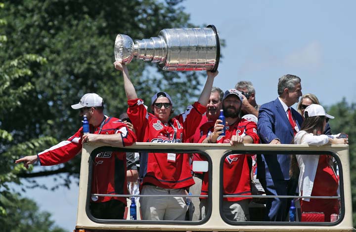 Washington Capitals center Nicklas Backstrom (19) from Sweden, holds up the Stanley Cup during a victory parade on Tuesday in Washington.