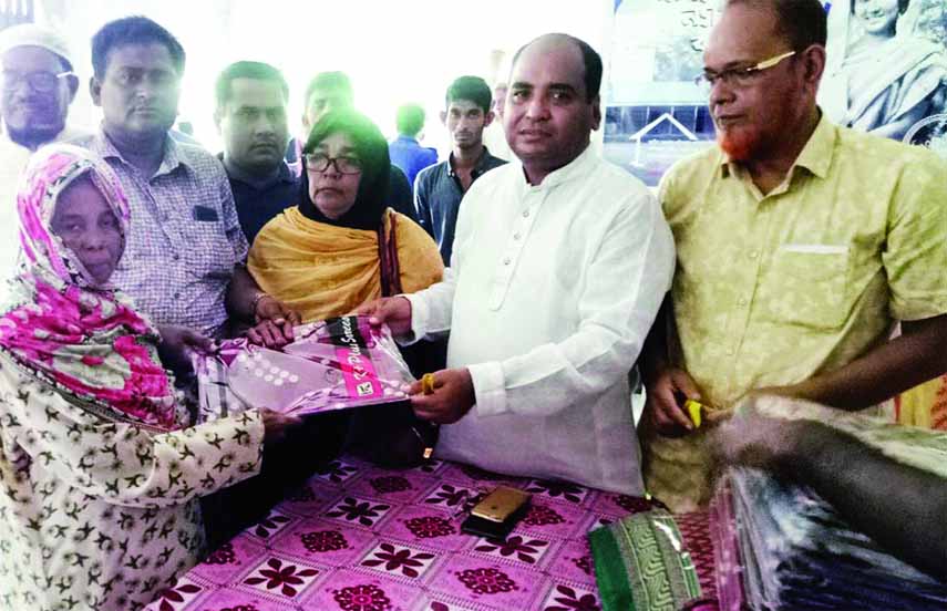 BHOLA: Ali Azam Mukul MP distributing sarees among the poor women in Bhola on Monday.