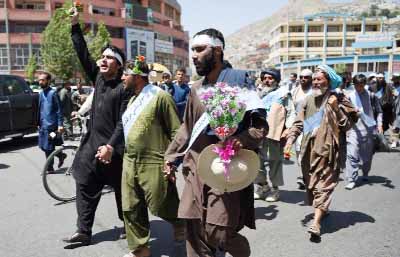 Afghan peace activists shout slogans demanding an end to fighting as they arrive in Kabul