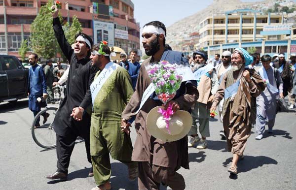 Afghan peace activists shout slogans demanding an end to fighting as they arrive in Kabul