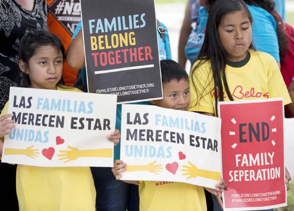 Children hold signs during a demonstration in front of the Immigration and Customs Enforcement offices in Miramar, Fla.