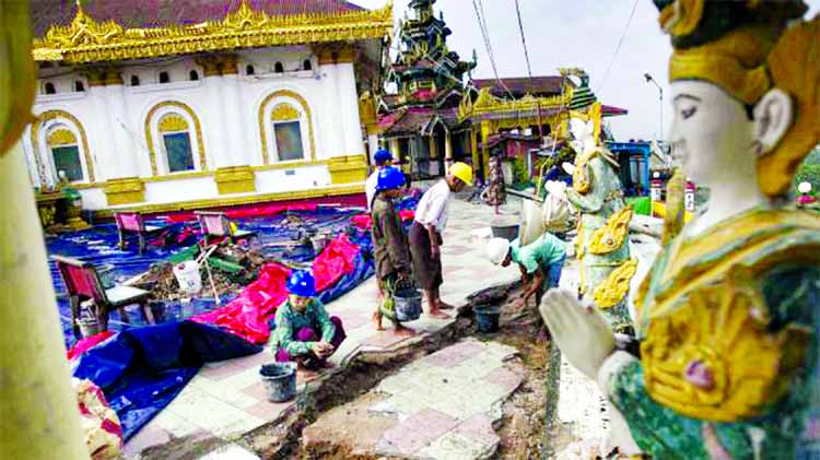Workers repair the damaged grounds of the hilltop Kyeik Than Lan pagoda in Mawlamyine capital of Myanmar on 18 June following heavy rains.