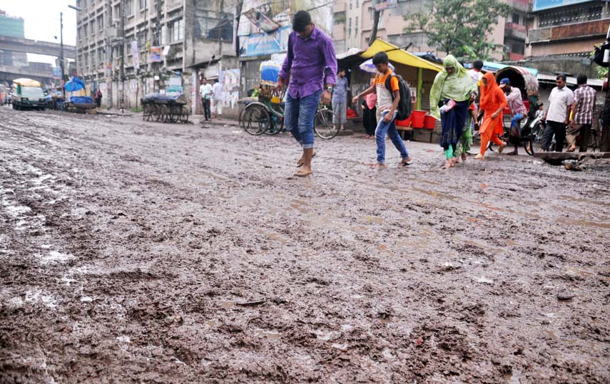 Pedestrians passing through a muddy road as the authority concerned does not repair the road for long time. The snap was taken from Bibir Bagicha area in the city's Jatrabari on Tuesday.