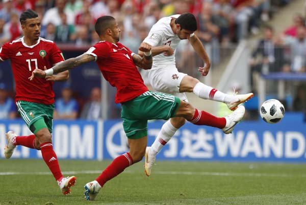 Portugal's Goncalo Guedes (right) shots on target as Morocco's Manuel Da Costa (center) challenges for the ball during the group B match between Portugal and Morocco at the 2018 soccer World Cup at the Luzhniki Stadium in Moscow, Russia, Wednesday. Port