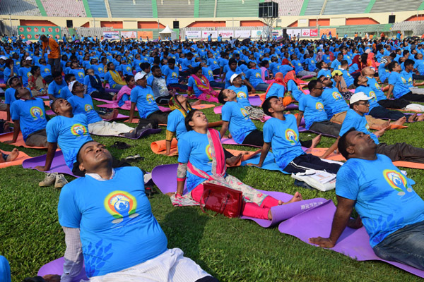 The performers showing Yoga at the Bangabandhu National Stadium on Thursday. Yoga enthusiasts across the world took part in mass yoga events to mark International Yoga Day.