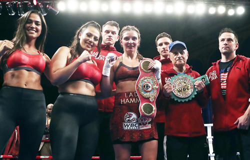Christina Hammer, of Germany, holds her championship belts after defeating Tori Nelson during their WBC and WBO women's middleweight championship boxing bout on Friday.