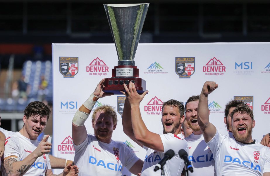 Members of England's rugby league team celebrate a win over New Zealand by raising the Rugby League Football International Challenge Cup on Saturday in Denver. England won 36-18.