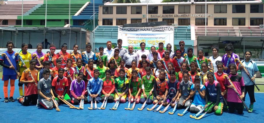 The female hockey players of the residential training camp with the officials of Sports Directorate pose for a photo session at the Maulana Bhashani National Hockey Stadium on Tuesday.