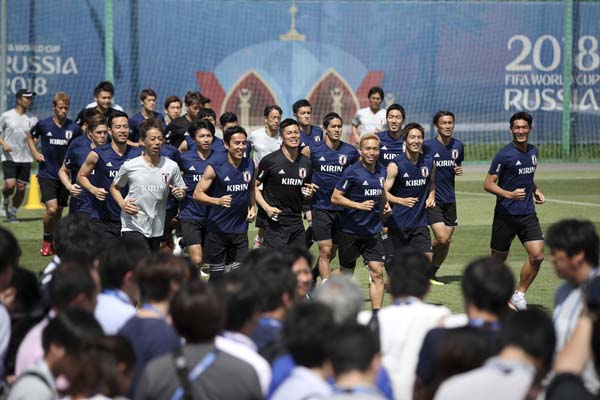 Japanese players run as the media attend the training session of Japan at the 2018 soccer World Cup in Kazan, Russia on Saturday. Japan play with Belgium in their round of 16 match tomorrow.