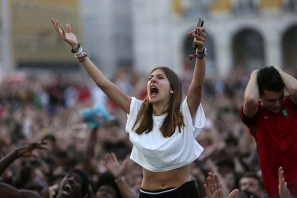 Portugal's supporters react while watching the 2018 soccer World Cup match between Portugal and Uruguay being shown on a video screen in Lisbon's Comercio square on Saturday.